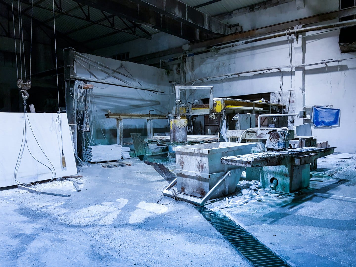 Laboratorio di taglio della pietra industriale con grandi macchinari e lastra di pietra.